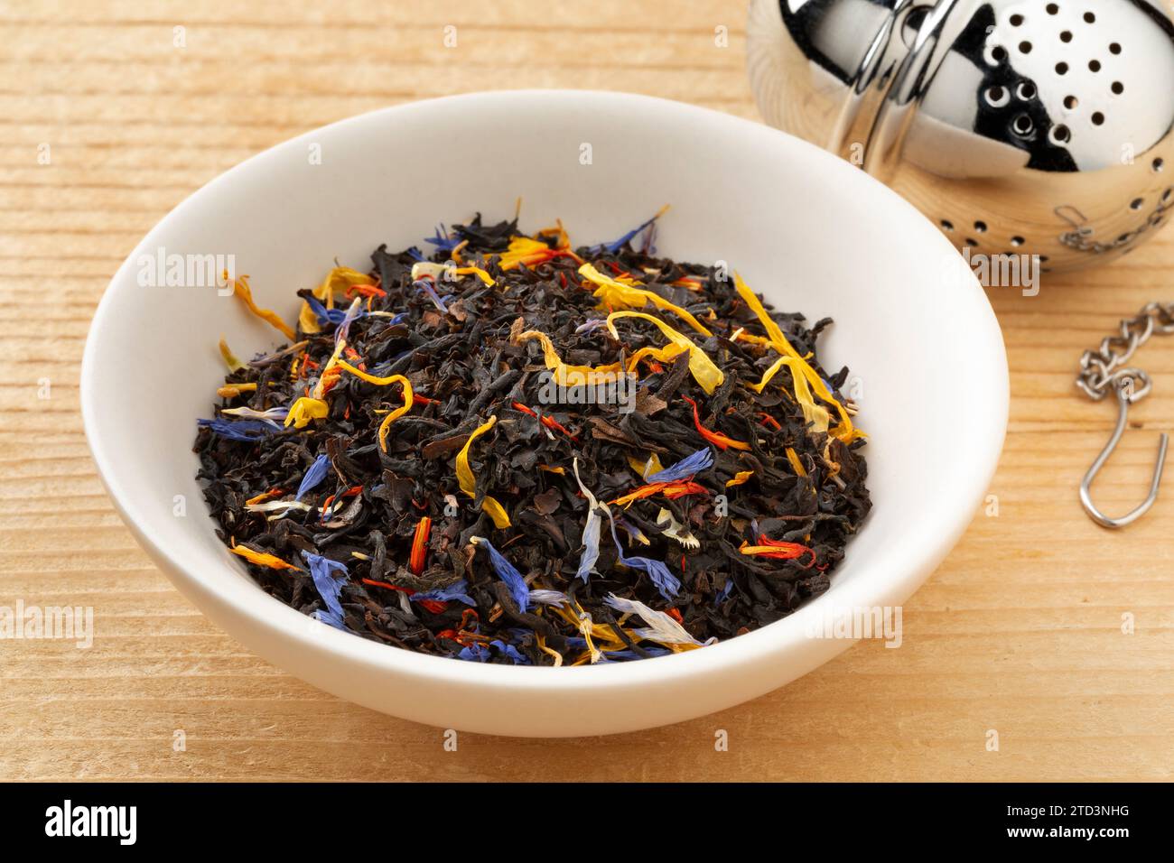 Recipiente in ceramica con tè nero con foglie di fiori secche da vicino Foto Stock