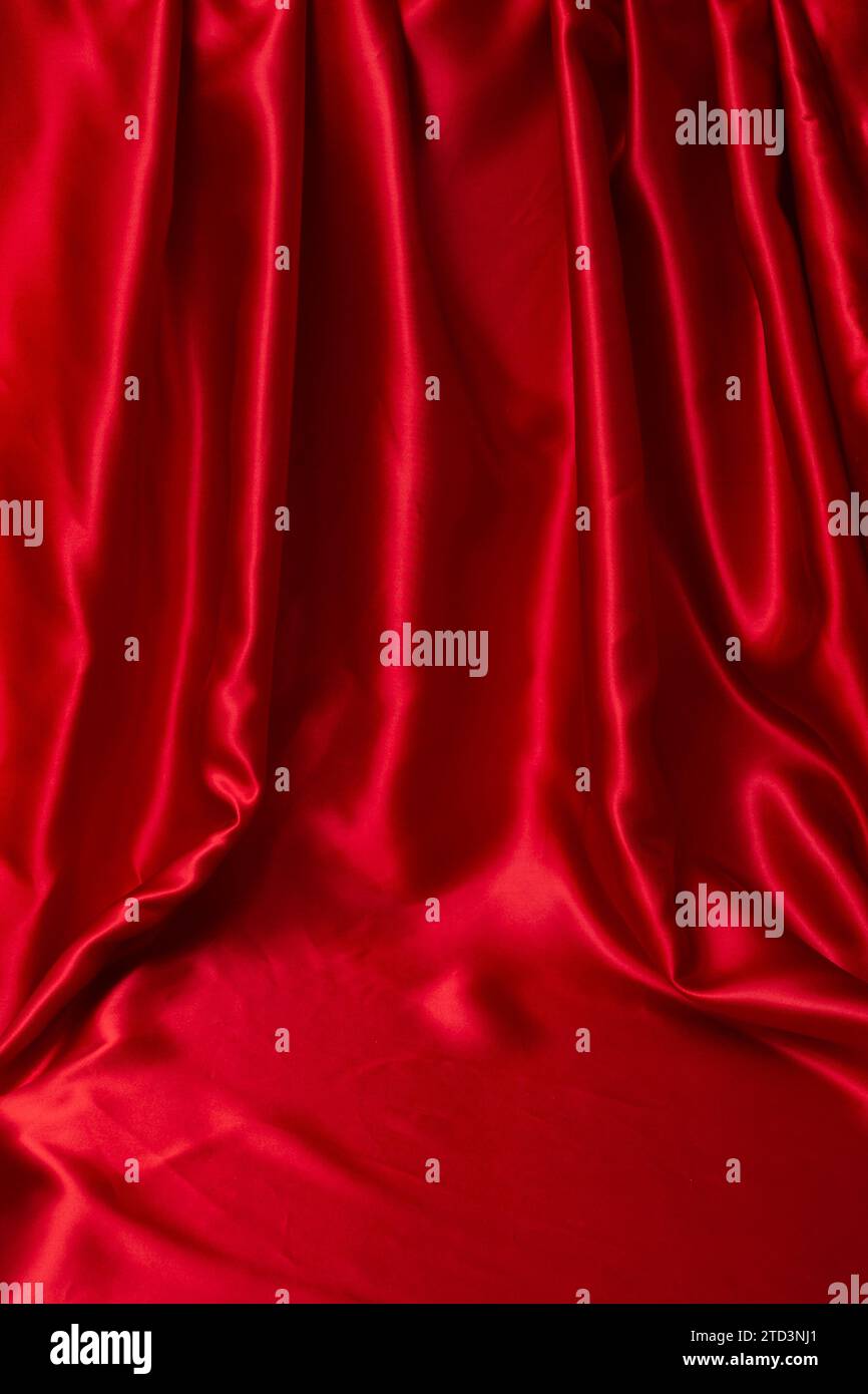 Raso rosso con pieghe e spazio vuoto per il posizionamento del testo o del prodotto, sfondo astratto Foto Stock