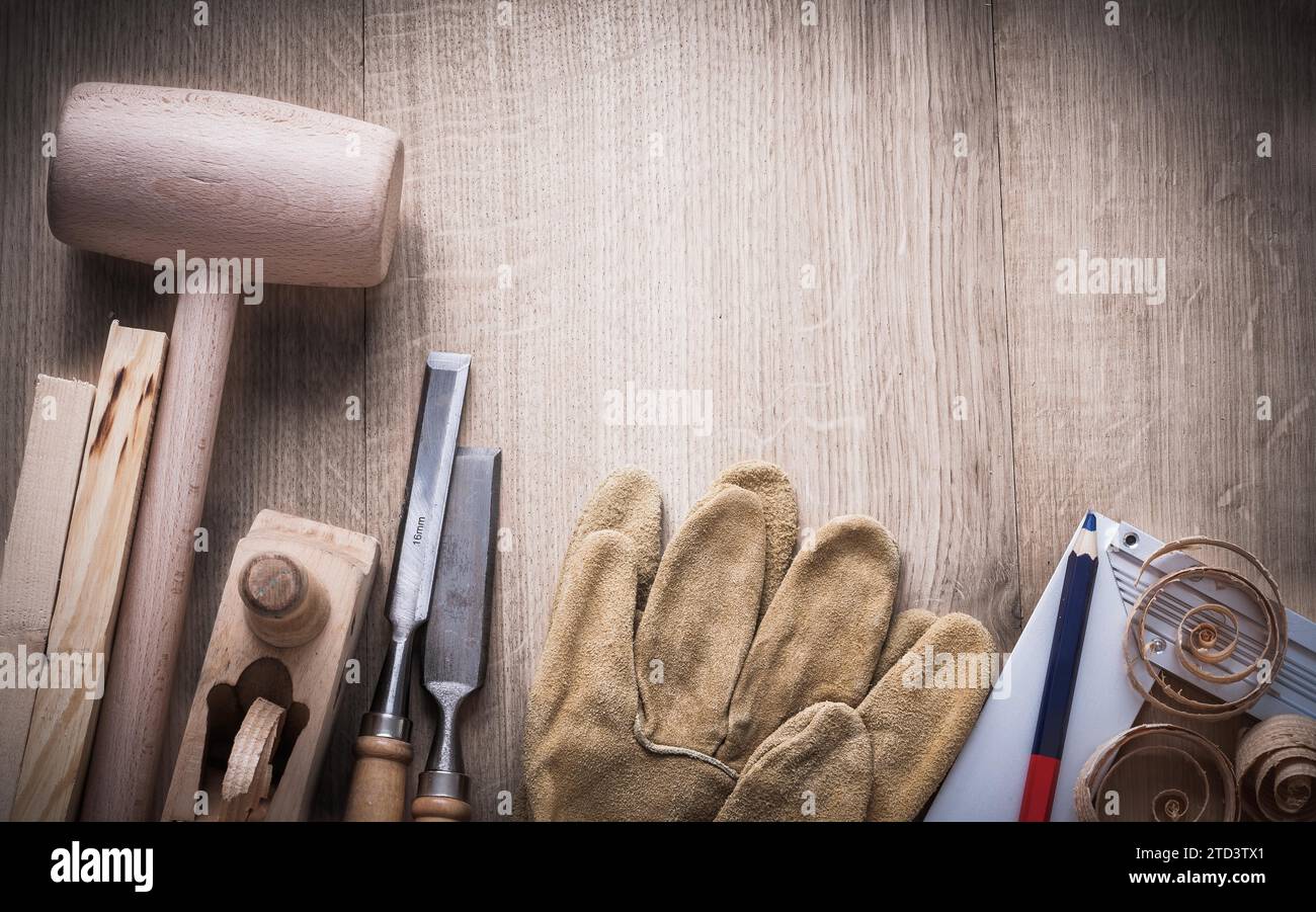 Composizione di utensili per carpenteria, trucioli e guanti in pelle basata sul concetto di costruzione di pannelli in legno Foto Stock