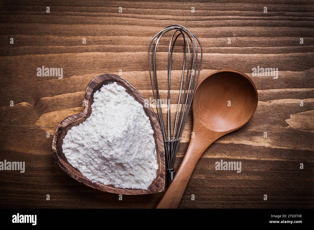 Composizione di cucchiaio di legno ciotola a forma di cuore frusta per fiori Foto Stock