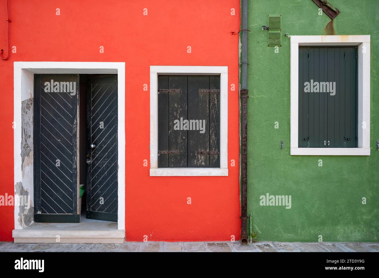 Facciata rossa e verde con porta d'ingresso e finestre, case colorate sull'isola di Burano, Venezia, Veneto, Italia Foto Stock