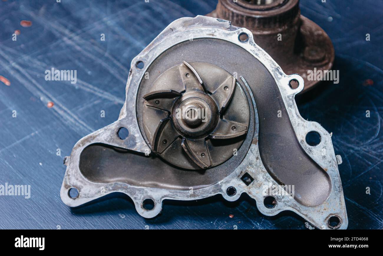 Ricambi auto usati, pompa del liquido di raffreddamento e mozzo ruota. Concetto di riparazione auto Foto Stock
