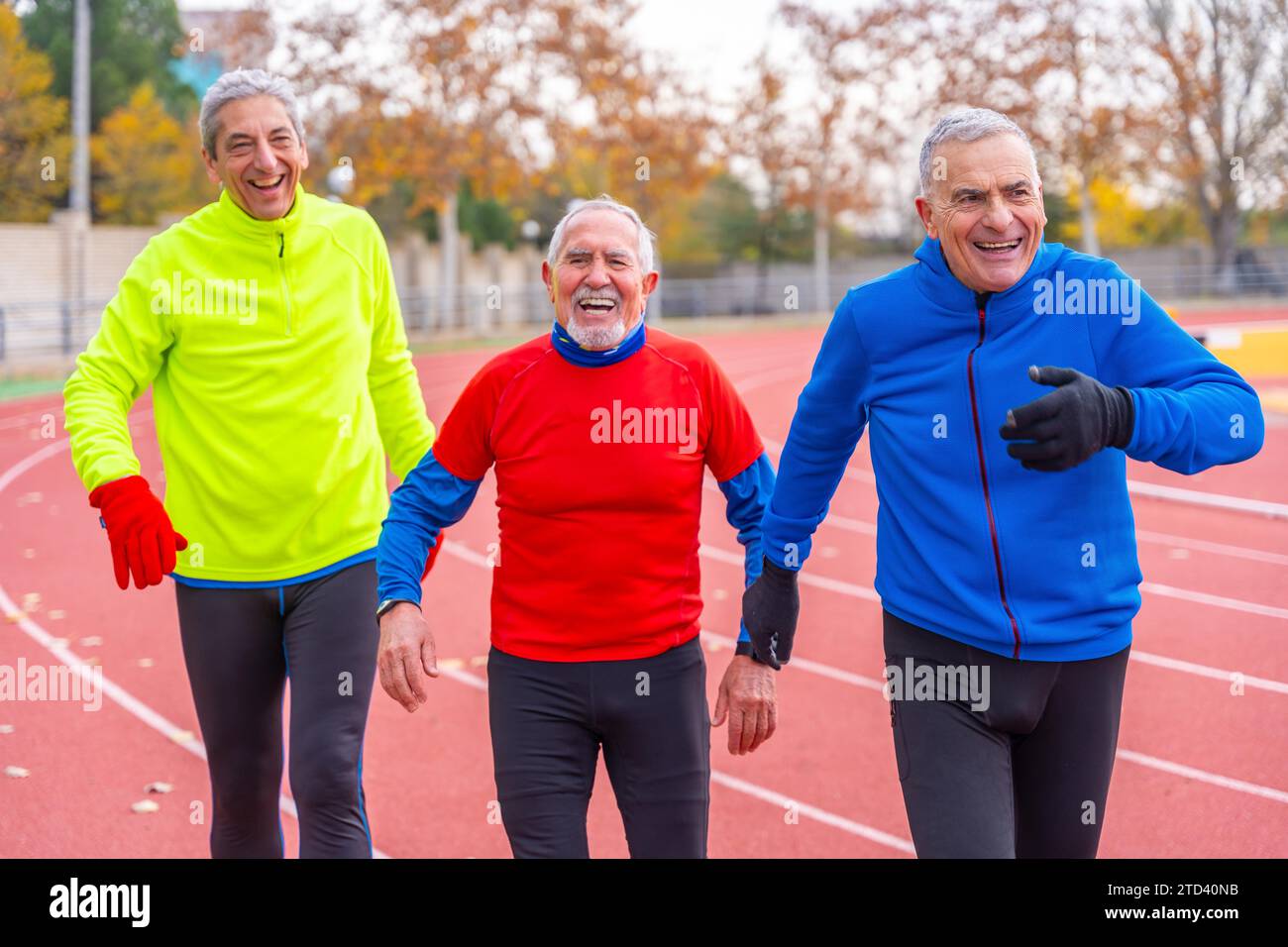 Uomini anziani stanchi dopo aver corso in una pista sportiva all'aperto in inverno Foto Stock