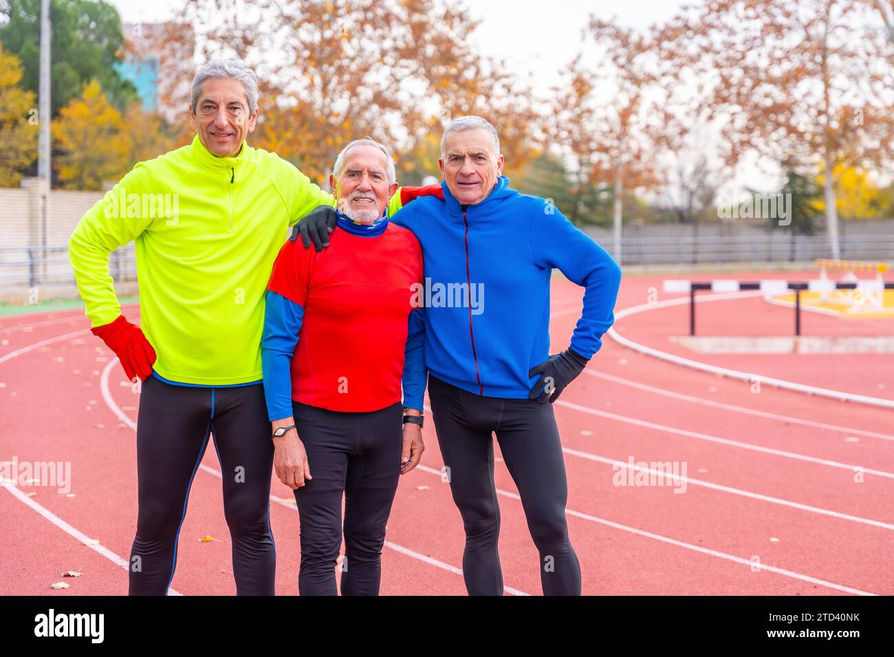 Ritratto di amici anziani in pensione sportivi in una pista da corsa all'aperto in inverno Foto Stock