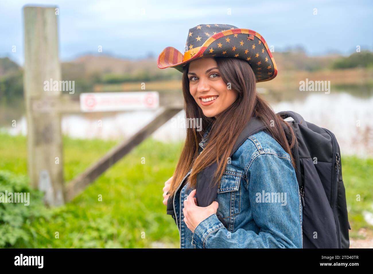 Foto orizzontale con spazio per la copia di un viaggiatore solitario sorridente davanti alla fotocamera che cammina lungo un percorso Foto Stock