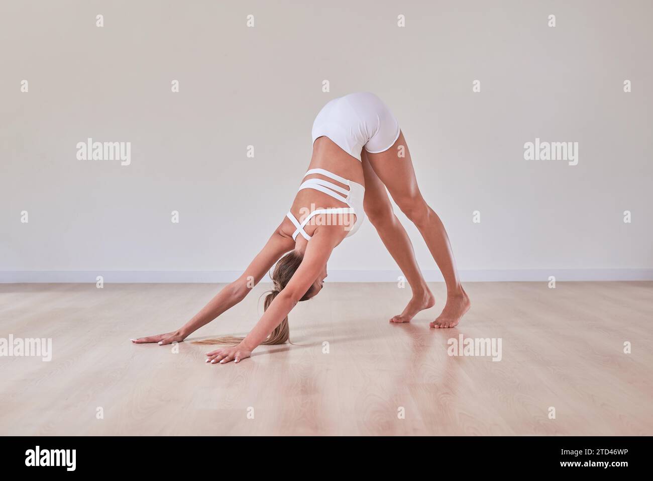 La donna flessibile si sta allenando in uno studio di illuminazione. Il concetto di ginnastica, stretching, Pilates. Stile di vita sano. Supporti misti Foto Stock