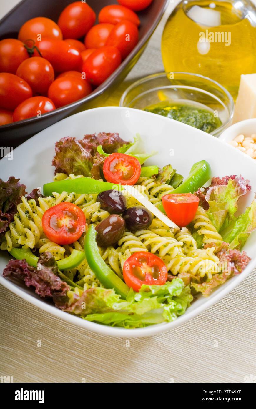 Insalata di pasta fresca e salutare con fusilli italiani fatti in casa con parmigiano, pomodori ciliegini pachino, olive nere e verdure miste, condite con Foto Stock