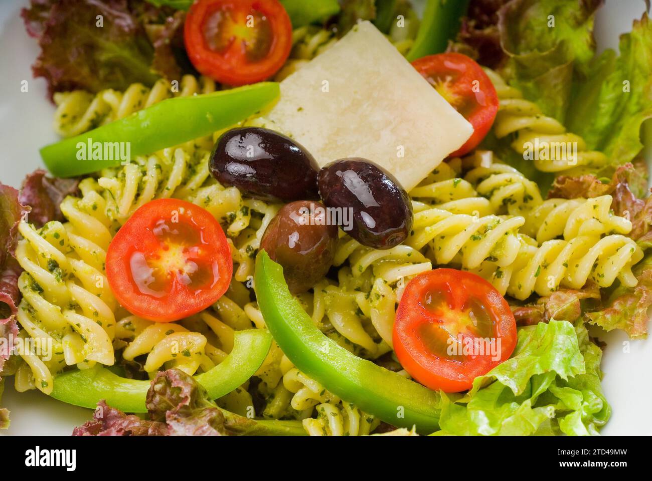 Insalata di pasta fresca e salutare con fusilli italiani fatti in casa con parmigiano, pomodori ciliegini pachino, olive nere e verdure miste, condite con Foto Stock