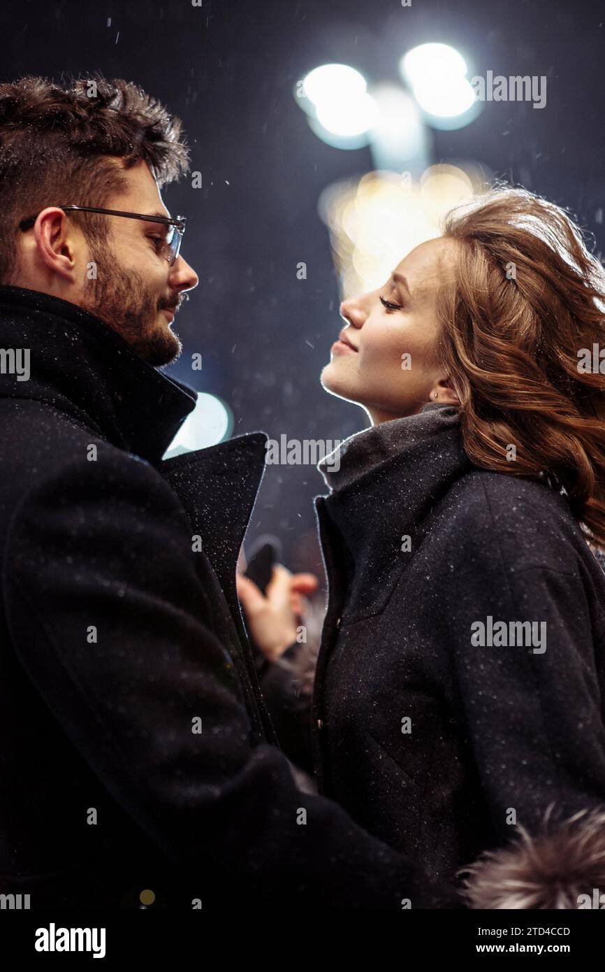 Giovane bella coppia innamorata di ballare in città sotto le nevicate il giorno di san valentino Foto Stock