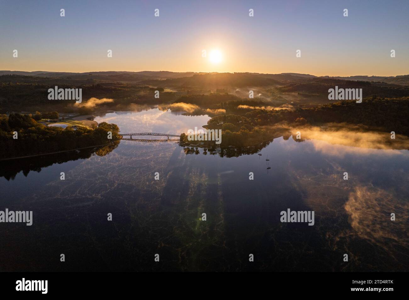 Vista aerea del Lac de Saint Pardoux e della sua passerella all'alba in autunno con nebbia e specchi d'acqua Foto Stock
