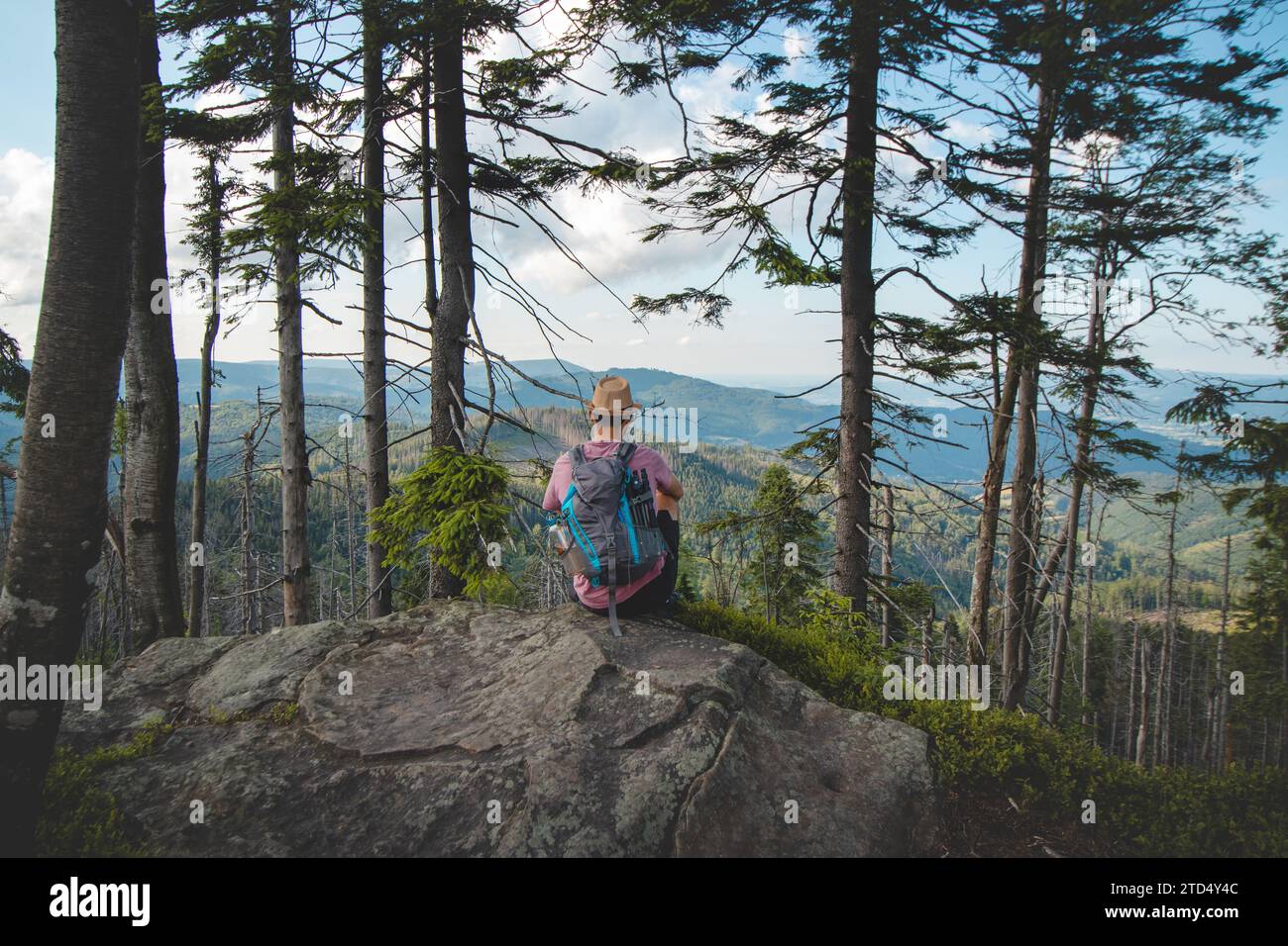 Backpacker di 20-25 anni riposa su una roccia guardando la valle sottostante, le montagne di Beskydy, Repubblica Ceca. Foto Stock