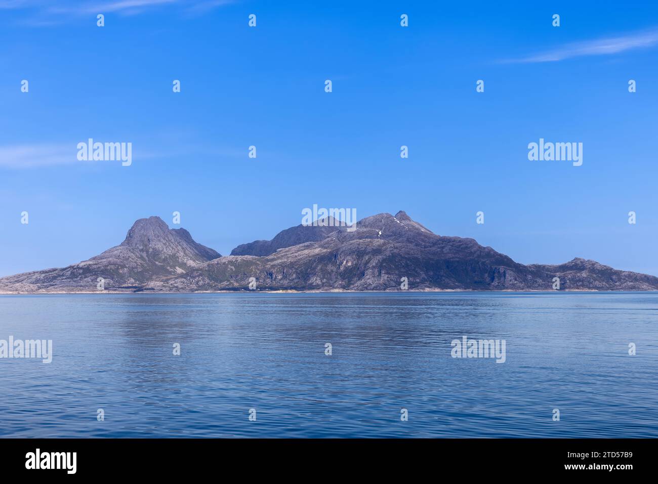 Una vista pittoresca del Mare del Nord e un'aspra montagna che torreggia sulle sue acque calme, vista da un traghetto per l'Isola di Lofoten, in una soleggiata giornata estiva Foto Stock