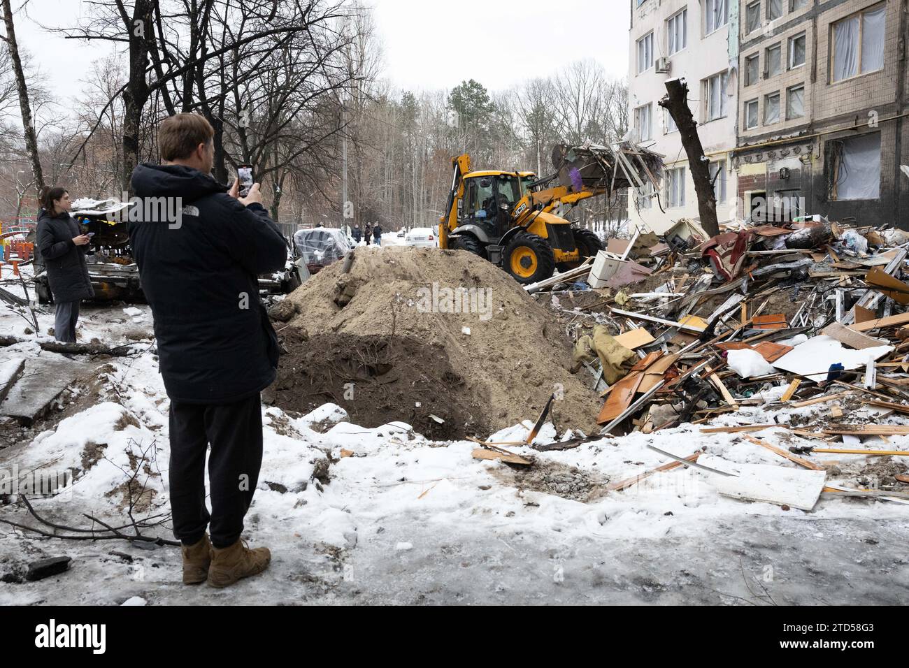 I lavoratori comunali riempiono un cratere creato dall'esplosione di un missile balistico russo a Kiev. Almeno 53 persone sono rimaste ferite nelle prime ore del 13 dicembre a causa della caduta di detriti missilistici in diversi distretti della capitale Ucraina Kiev, dopo che i sistemi di difesa aerea hanno intercettato i missili balistici russi in arrivo. Foto Stock