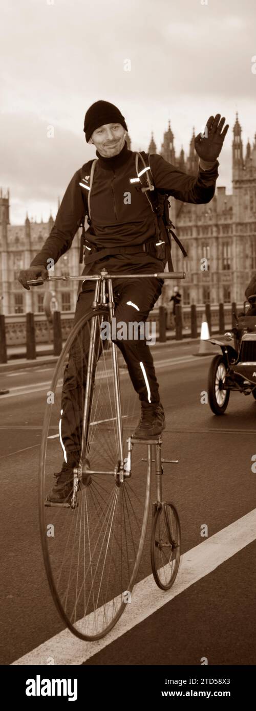 Ciclista Sepia Tone, partecipante Penny-Farthing sul Westminster Bridge di Londra, fino alla Brighton Veteran Car Run Foto Stock