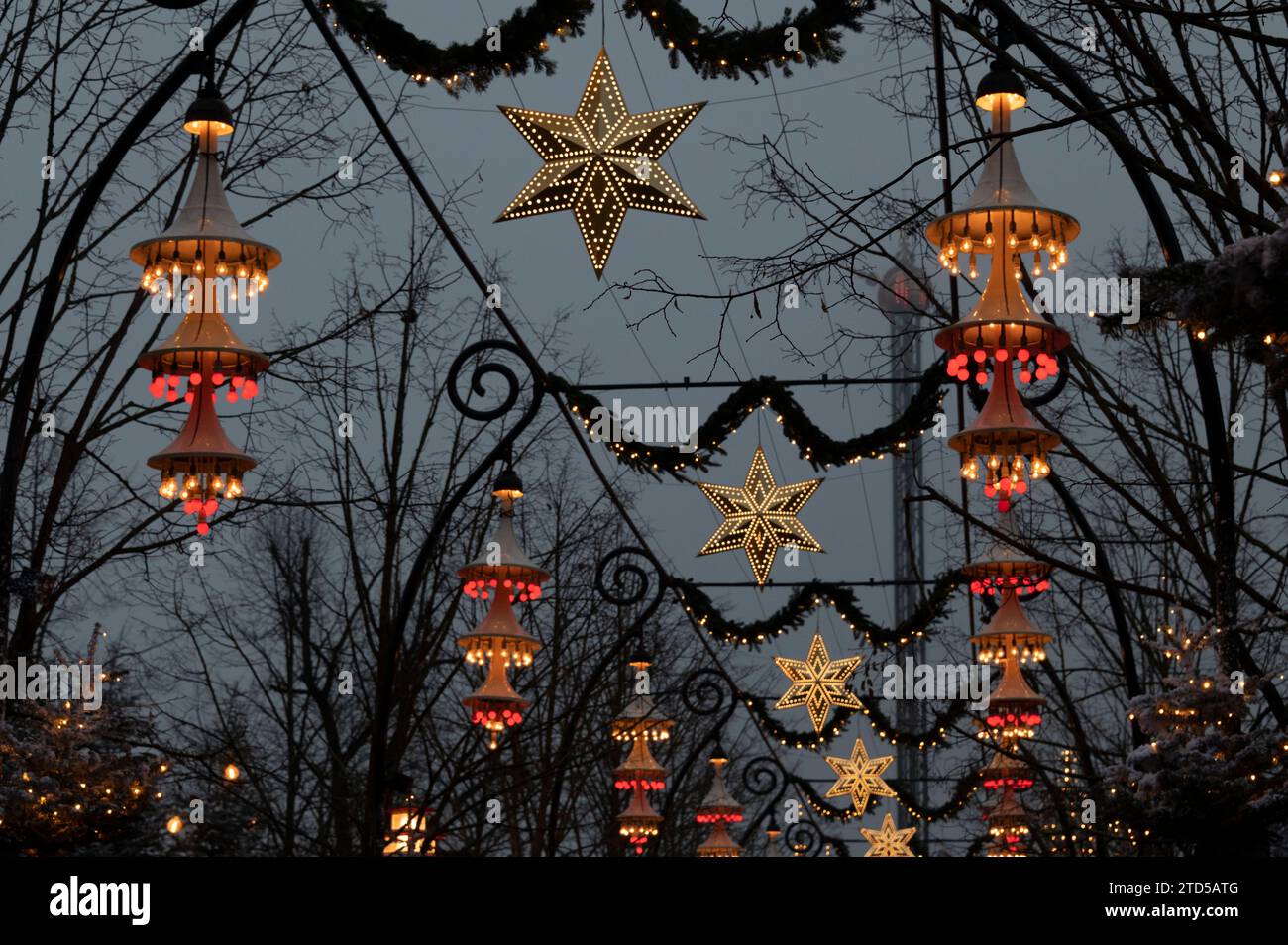 Luci natalizie sospese lungo uno degli ampi sentieri dei Giardini di Tivoli. Fa parte del Julemarked (mercato di Natale) a Copenh Foto Stock