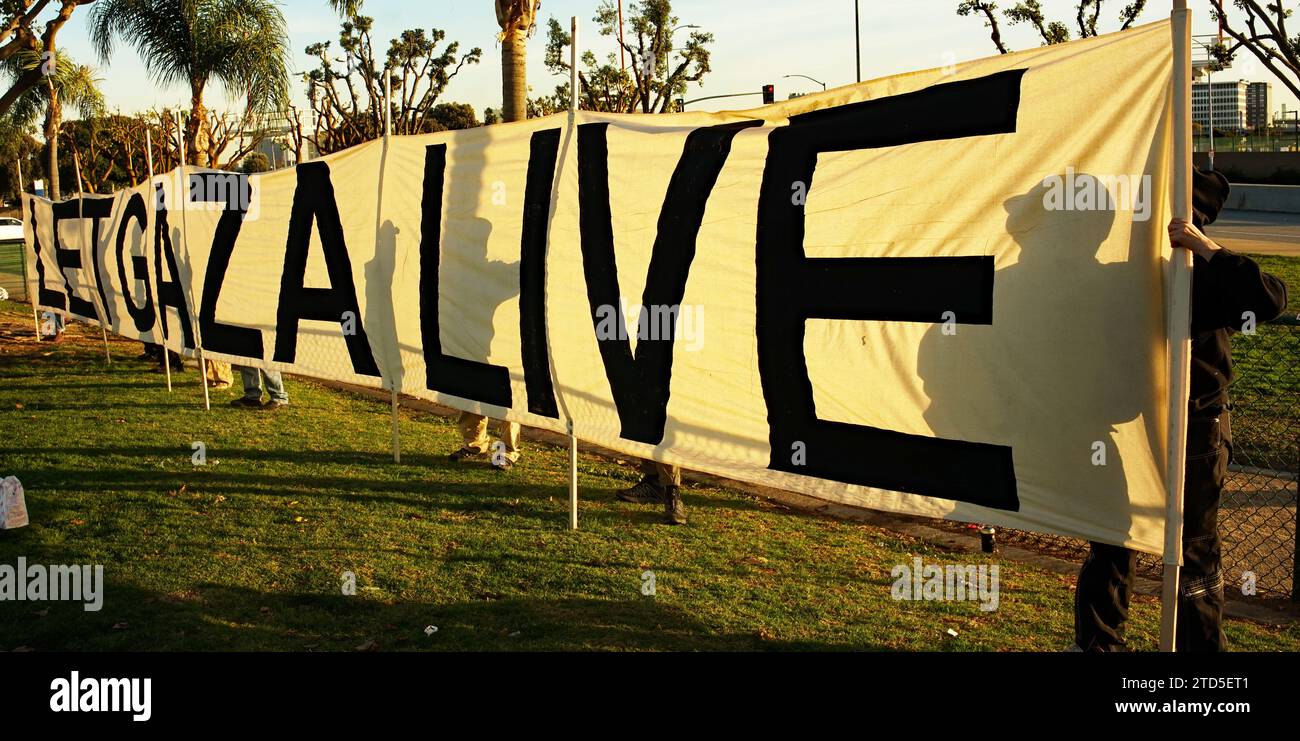 15 dicembre 2023, un gruppo di manifestanti che si autodefinivano Shut IT Down organizzò una manifestazione nei pressi dell'aeroporto internazionale di Los Angeles (LAX) per chiedere la fine dell'occupazione israeliana della Palestina e del genocidio di Gaza. I manifestanti, che si identificarono come palestinesi, ebrei e angelone di coscienza, marciarono per ore intorno all'aeroporto, bloccando il traffico e affrontando la polizia. Hanno portato cartelli che recitano “fermare il genocidio di Gaza”, “Palestina libera” e “Biden Out”. Hanno anche cantato slogan come "Nessuna giustizia, nessuna pace", "Palestine Lives Matter" e "End Apartheid". Foto Stock