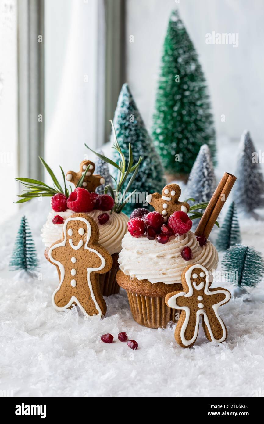 Deliziosi cupcake al pan di zenzero circondati da decorazioni natalizie. Foto Stock