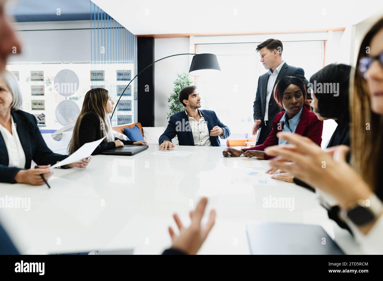 Team aziendale multirazziale che tiene un briefing nella sala riunioni di un moderno ufficio - brainstorming e concetto di lavoro di squadra Foto Stock