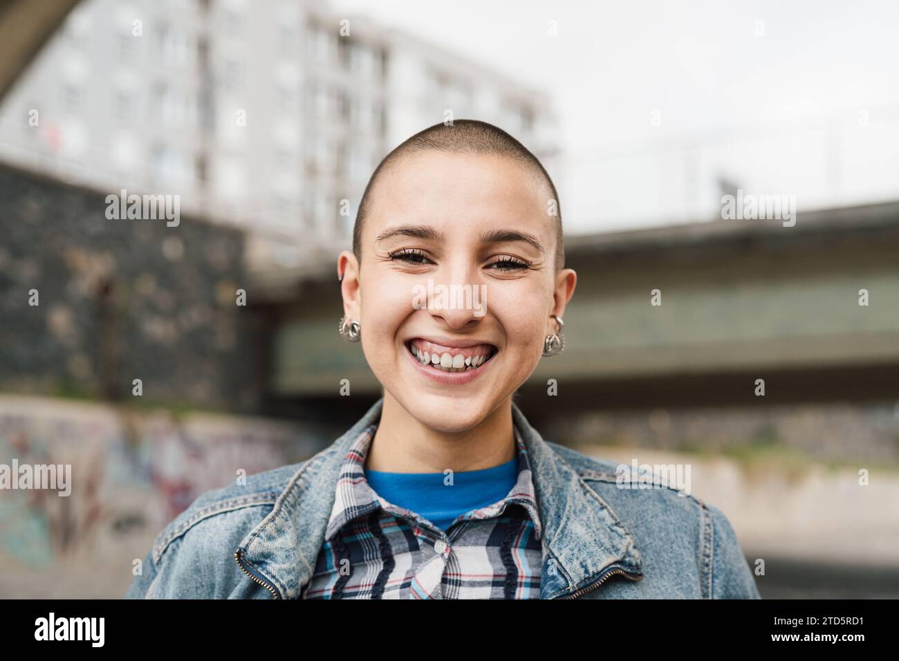 Giovane donna felice con la testa rasata sorridente davanti alla fotocamera Foto Stock