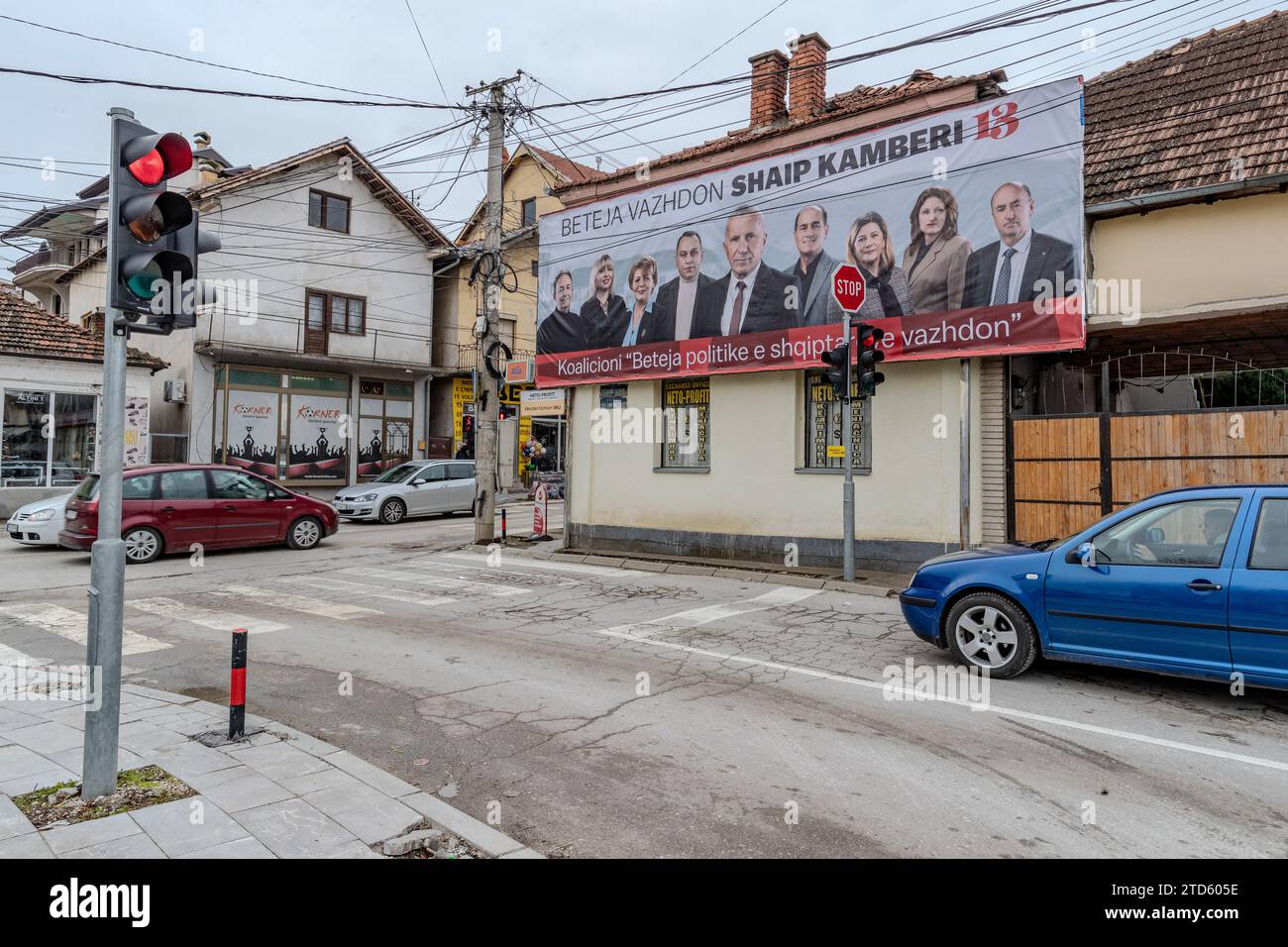 Preshevo, Repiblic di Serbia. 16 dicembre 2023. A Preshevo i pedoni passano un poster della campagna elettorale di Shaip Kamberi, un albanese che si candida per la rielezione come deputato all'Assemblea serba con una coalizione a cinque partiti. Questa scena mette in luce le preoccupazioni della comunità albanese circa il crescente potere di Aleksandar Vucic e le sue implicazioni per la loro sicurezza e posizione in Serbia. (VX Photo/ Vudi Xhymshiti) credito: VX Pictures/Alamy Live News Foto Stock