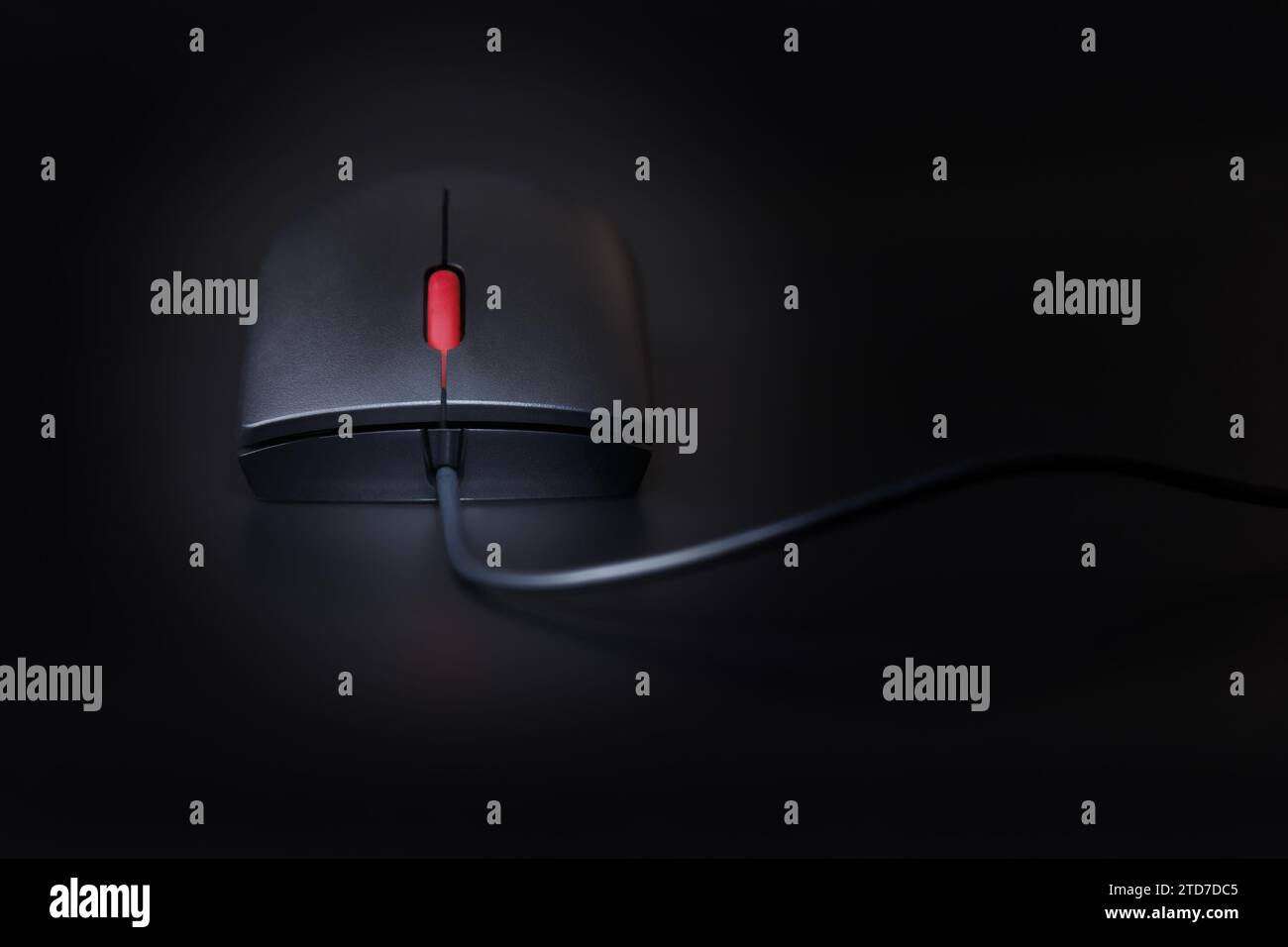Mouse per computer nero con rotellina di scorrimento rossa, primo piano su sfondo scuro con profondità di campo ridotta Foto Stock