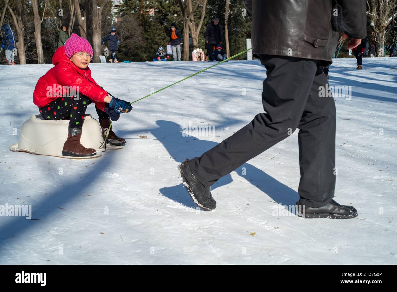 Una ragazza cinese e suo nonno giocano nella neve in un parco a Pechino, in Cina.17 dic-2023 Foto Stock