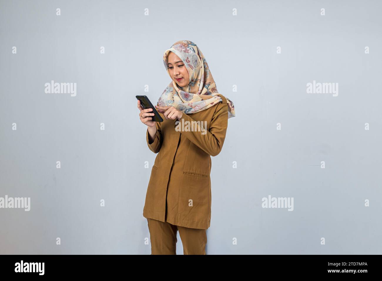 Giovane donna indonesiana dipendente del governo che indossa un'uniforme marrone. Foto Stock