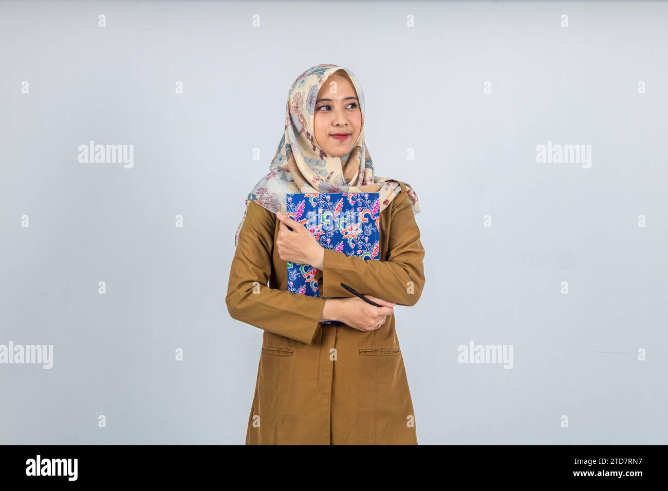 Giovane donna indonesiana dipendente del governo che indossa un'uniforme marrone. Foto Stock