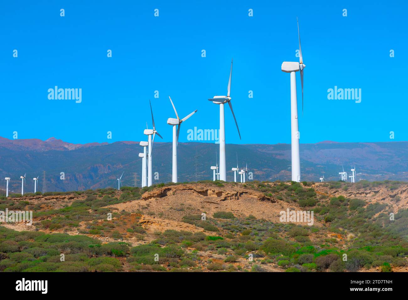 Mulini a vento per la produzione di energia elettrica . Le gigantesche turbine eoliche sono posizionate sulle creste, sfruttando la potenza del vento Foto Stock