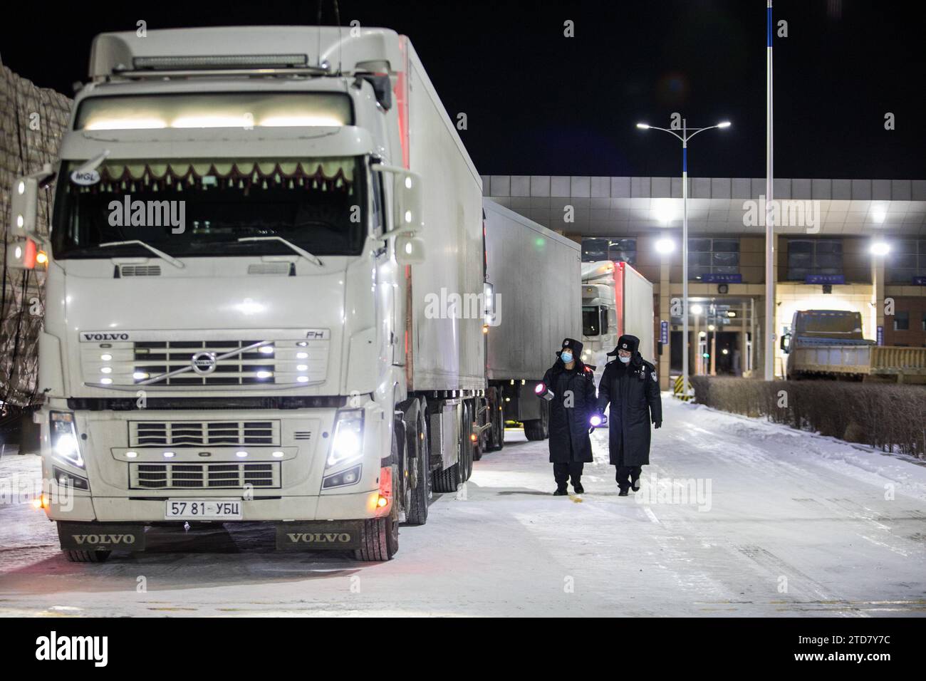 Erenhot. 16 dicembre 2023. Gli agenti di polizia ispezionano i veicoli da carico nel porto autostradale di Erenhot, nella regione autonoma della Mongolia interna della Cina del nord, 16 dicembre 2023. Il porto autostradale di Erenhot, il più grande porto terrestre sul confine tra Cina e Mongolia, ha iniziato lo sdoganamento merci 24 ore su 24 su base sperimentale sabato. È il primo porto cinese sul confine tra Cina e Mongolia ad aver implementato il servizio 24 ore su 24. Crediti: Guo Pengjie/Xinhua/Alamy Live News Foto Stock