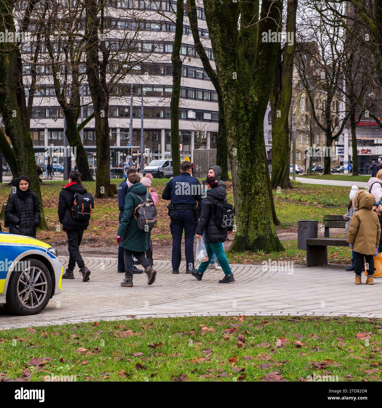 Gli agenti di polizia parlano con la gente in una piazza pubblica in Germania Foto Stock