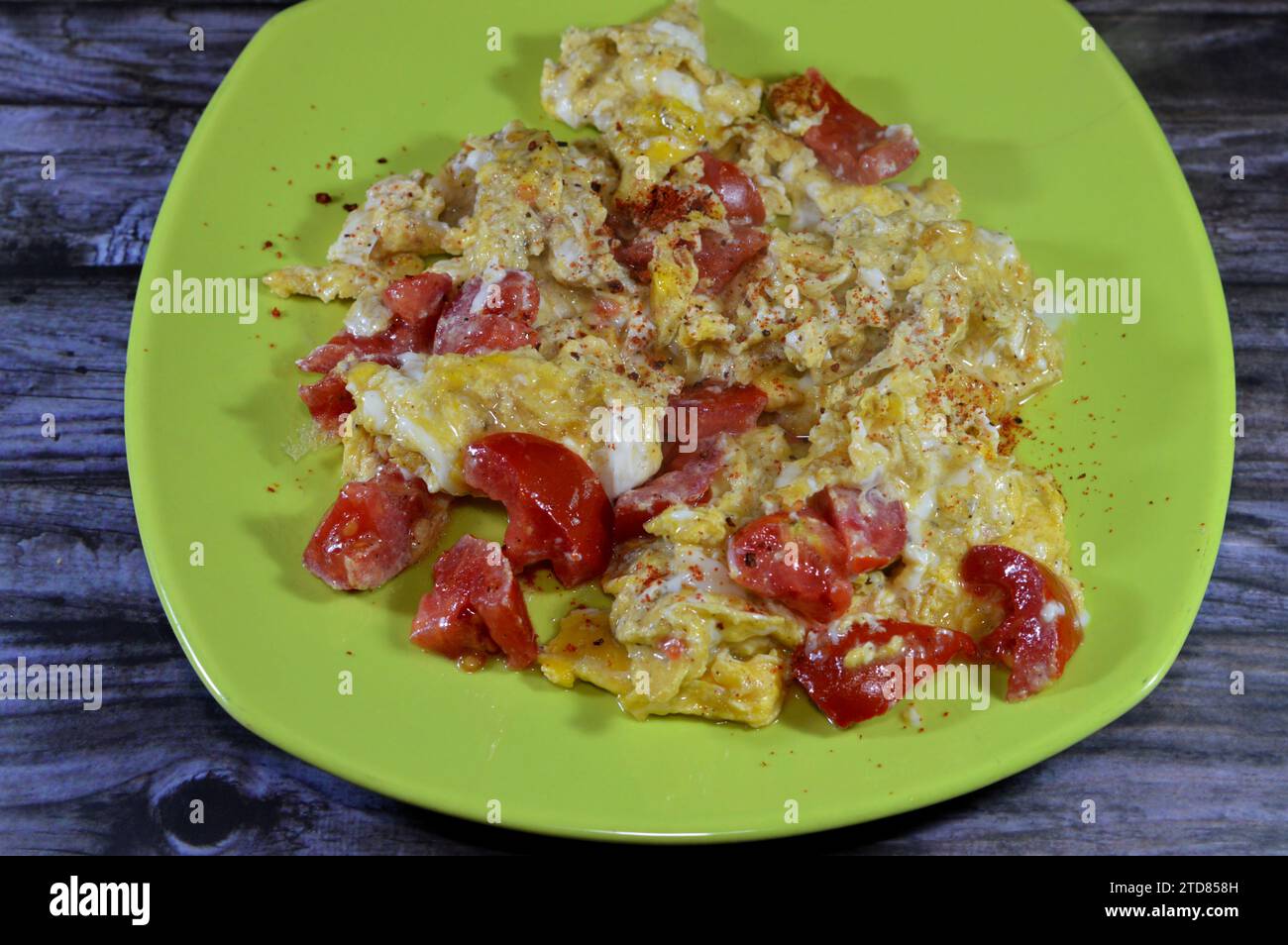 Uova strapazzate con pomodori, un piatto a base di uova mescolate, montate o sbattute insieme mentre vengono riscaldate delicatamente, con sale, burro, olio e pe nero Foto Stock