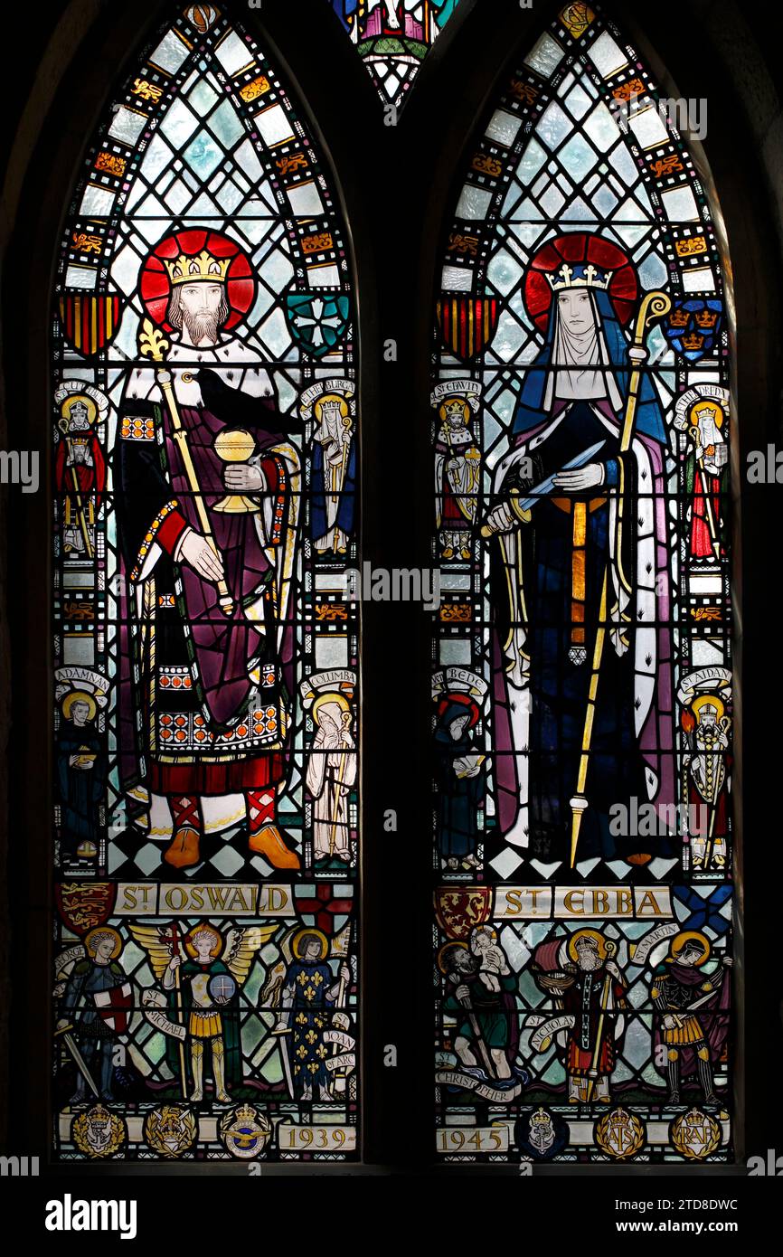 St Oswald e St Ebba raffigurate in vetrate colorate. La finestra del memoriale di guerra. St Ebba's Church, Beadnell, St Ebba Church, beadnell, Northumberland, REGNO UNITO Foto Stock