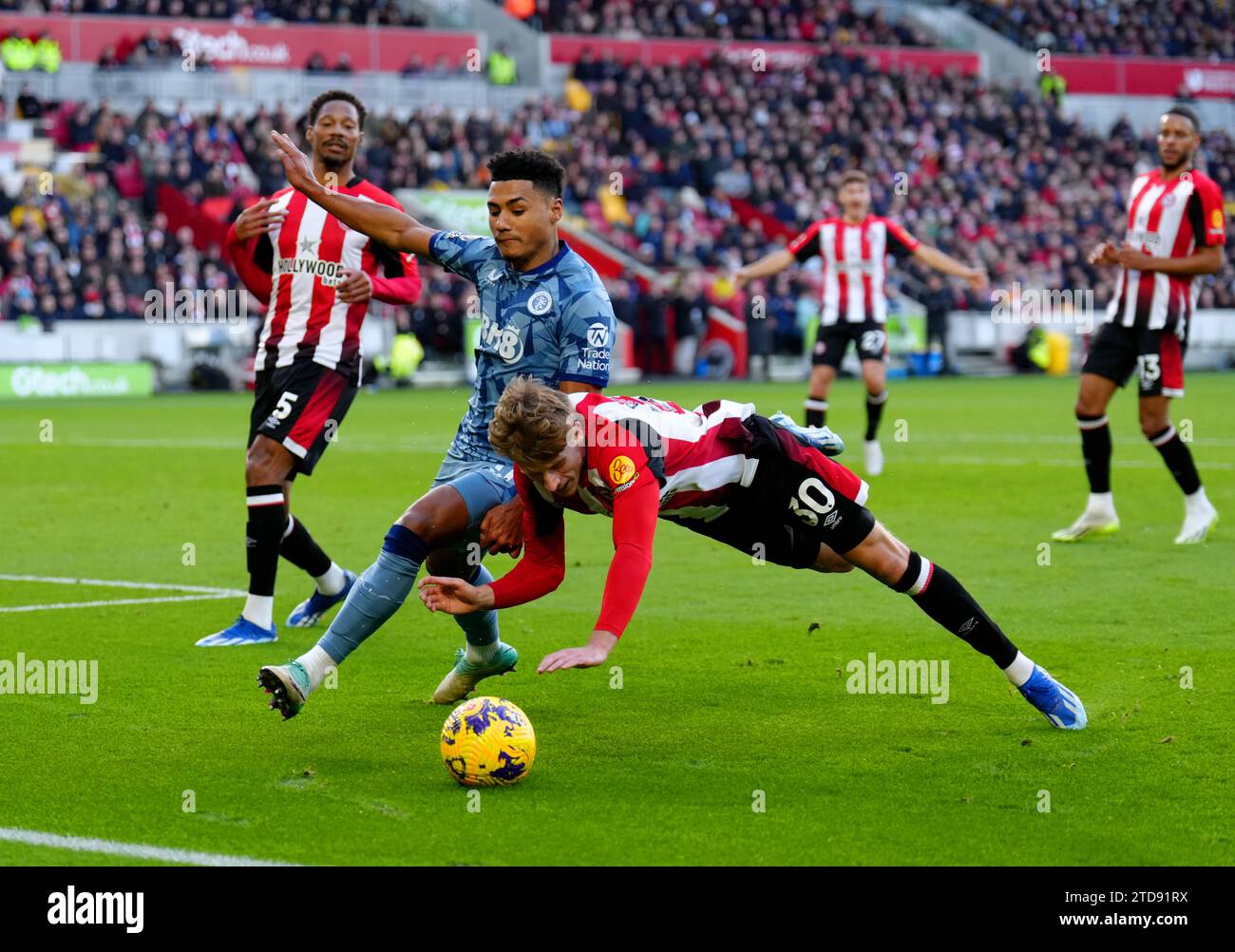 Mads Roerslev di Brentford va giù mentre combatte per la palla con Ollie Watkins dell'Aston Villa durante la partita di Premier League al Gtech Community Stadium di Londra. Data foto: Domenica 17 dicembre 2023. Foto Stock