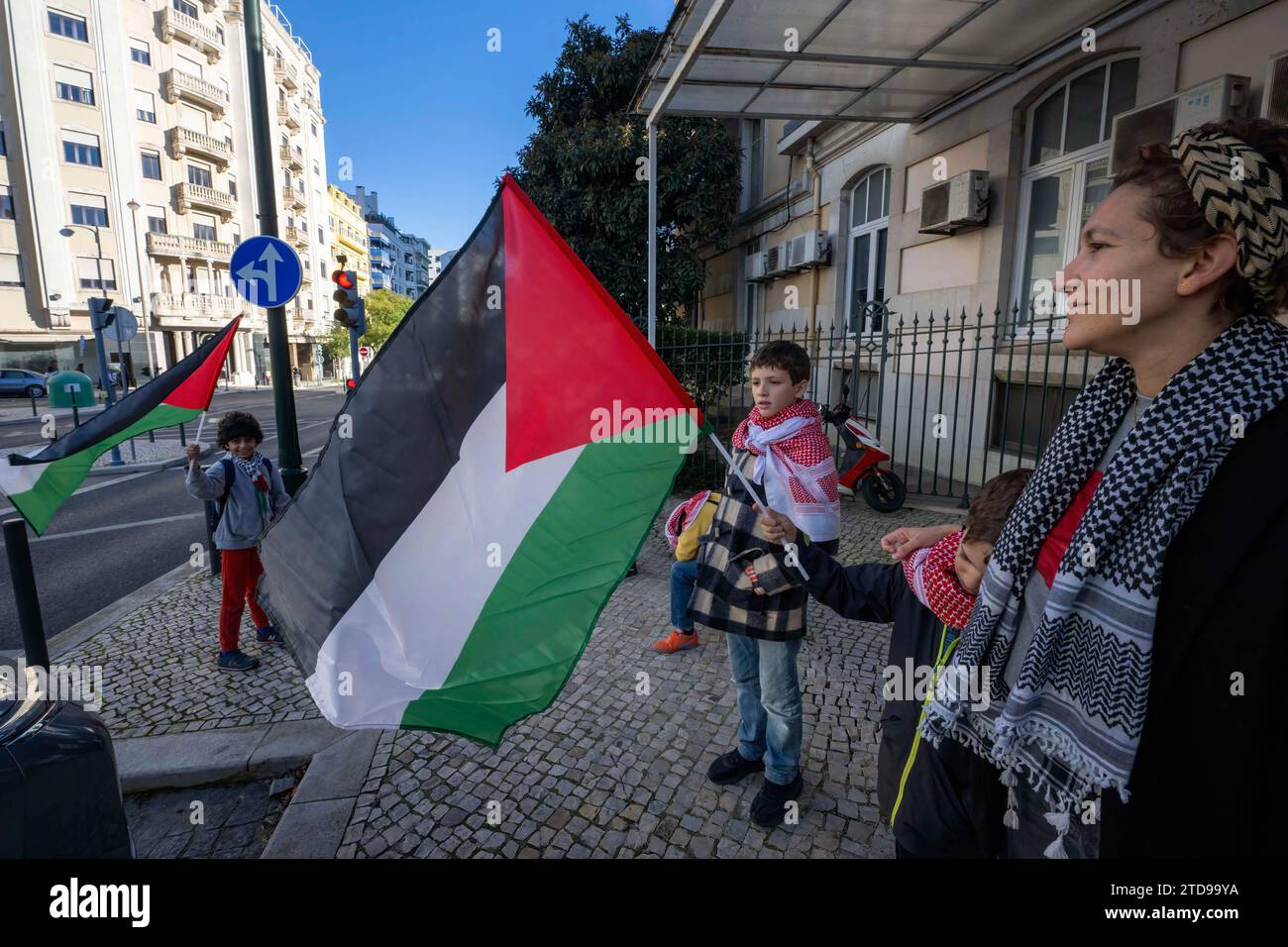 Lisbona, Portogallo. 16 dicembre 2023. Gli attivisti tengono bandiere palestinesi tengono una manifestazione vicino all'ambasciata israeliana. Le azioni di protesta sono state organizzate dal PUSP - Plataforma Unitária de Solidariedade com a Palestina, il che richiede al governo israeliano un cessate il fuoco immediato e permanente, la fine dell'assedio e l'ingresso illimitato di aiuti umanitari nella Striscia di Gaza, nonché la fine dell'aggressione nelle città, nei villaggi e nei campi profughi di tutta la Palestina. Credito: SOPA Images Limited/Alamy Live News Foto Stock