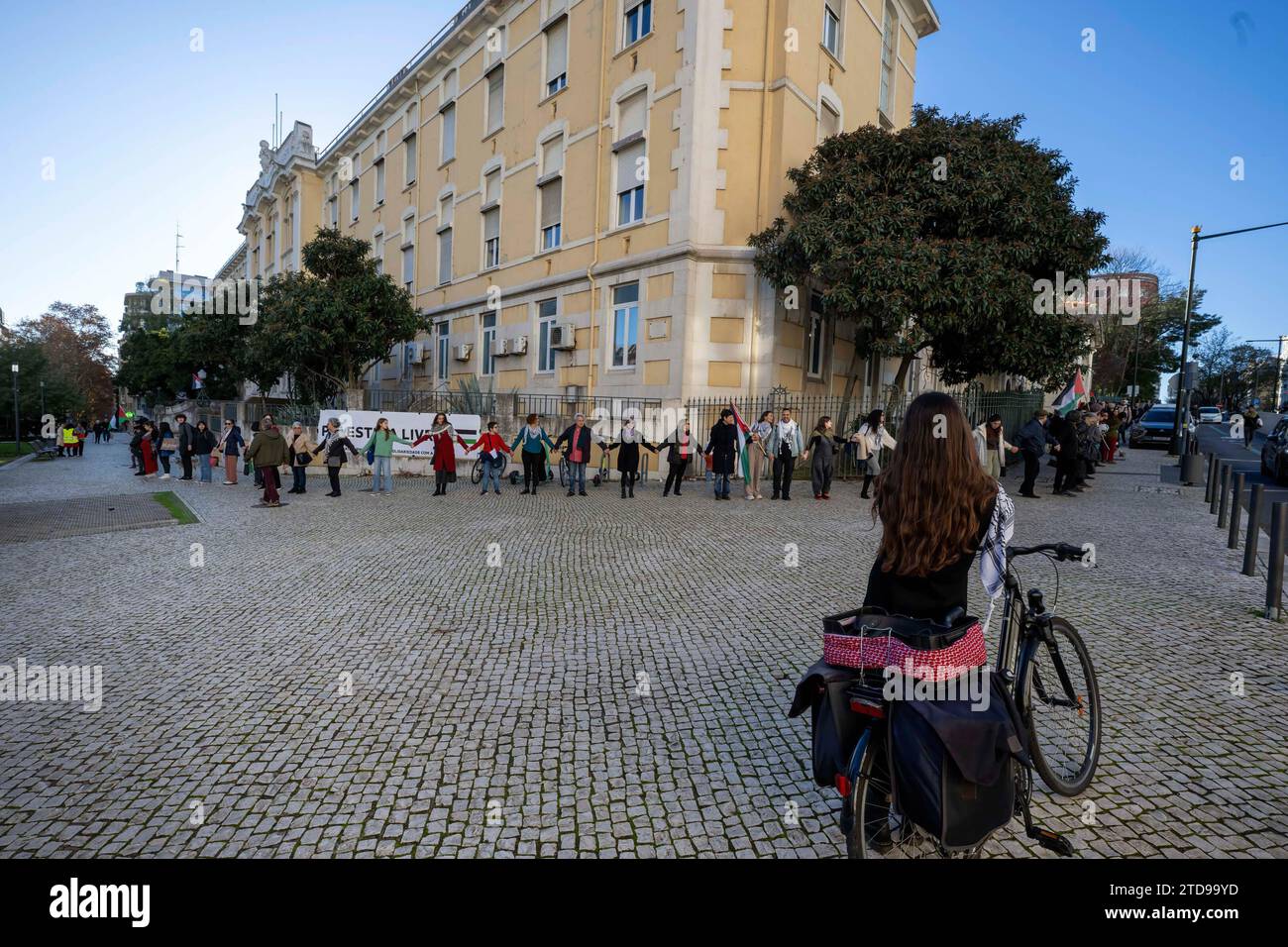 Lisbona, Portogallo. 16 dicembre 2023. Gli attivisti si tengono per mano durante una manifestazione vicino all'ambasciata israeliana. Le azioni di protesta sono state organizzate dal PUSP - Plataforma Unitária de Solidariedade com a Palestina, il che richiede al governo israeliano un cessate il fuoco immediato e permanente, la fine dell'assedio e l'ingresso illimitato di aiuti umanitari nella Striscia di Gaza, nonché la fine dell'aggressione nelle città, nei villaggi e nei campi profughi di tutta la Palestina. Credito: SOPA Images Limited/Alamy Live News Foto Stock