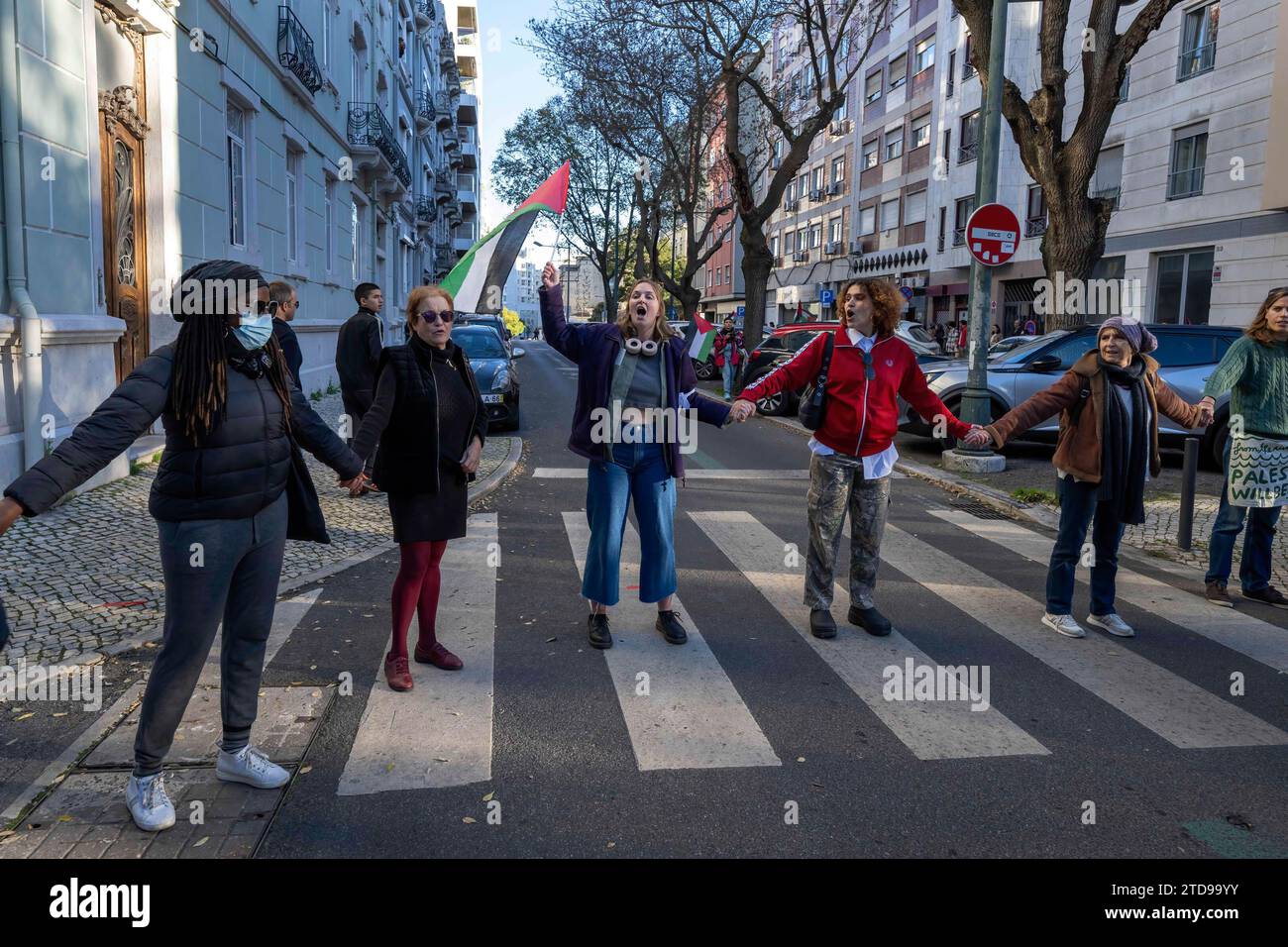 Lisbona, Portogallo. 16 dicembre 2023. Gli attivisti si tengono per mano durante una manifestazione vicino all'ambasciata israeliana. Le azioni di protesta sono state organizzate dal PUSP - Plataforma Unitária de Solidariedade com a Palestina, il che richiede al governo israeliano un cessate il fuoco immediato e permanente, la fine dell'assedio e l'ingresso illimitato di aiuti umanitari nella Striscia di Gaza, nonché la fine dell'aggressione nelle città, nei villaggi e nei campi profughi di tutta la Palestina. Credito: SOPA Images Limited/Alamy Live News Foto Stock