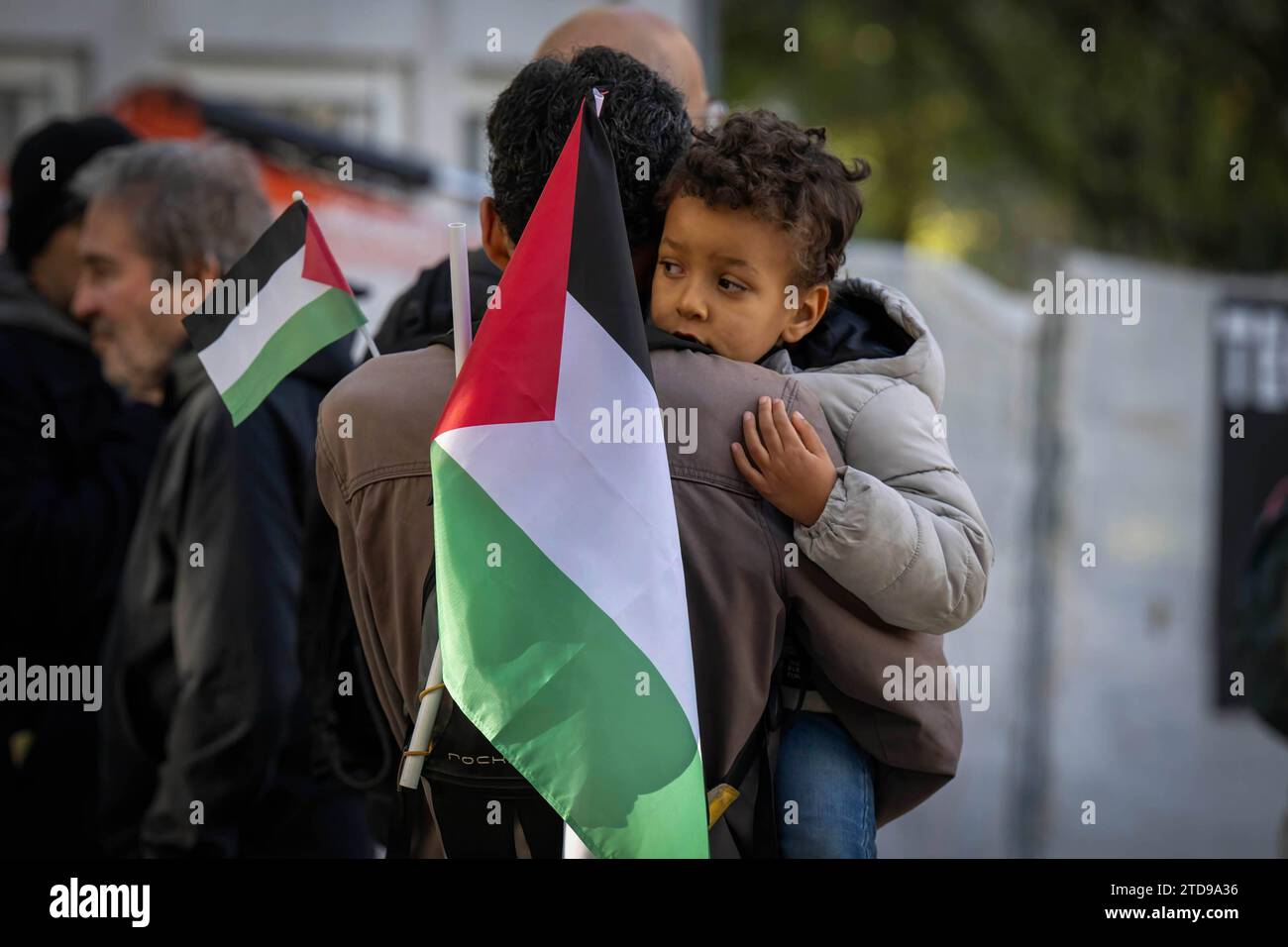 Lisbona, Portogallo. 16 dicembre 2023. Un attivista che porta un bambino tiene una bandiera palestinese durante una manifestazione vicino all'ambasciata israeliana. Le azioni di protesta sono state organizzate dal PUSP - Plataforma Unitária de Solidariedade com a Palestina, il che richiede al governo israeliano un cessate il fuoco immediato e permanente, la fine dell'assedio e l'ingresso illimitato di aiuti umanitari nella Striscia di Gaza, nonché la fine dell'aggressione nelle città, nei villaggi e nei campi profughi di tutta la Palestina. Credito: SOPA Images Limited/Alamy Live News Foto Stock