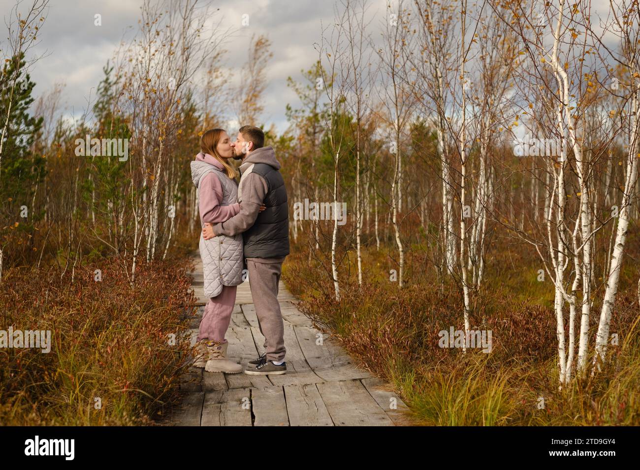 I turisti con gli zaini baciano un sentiero di legno in una palude a Yelnya, Bielorussia. Foto Stock