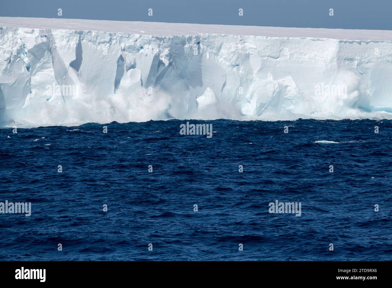 Antartide, Isole Orcadi meridionali. Onde che si infrangono su un grande iceberg tabulare che galleggia vicino alle Orcadi. Foto Stock