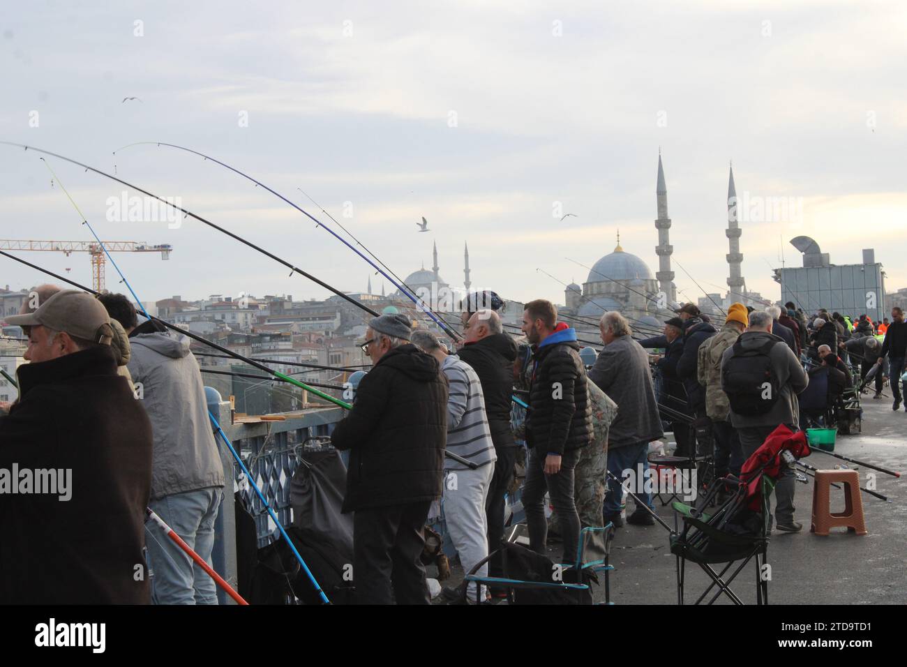 Uomini che pescano sul ponte sul Bosforo in inverno a Istanbul Foto Stock