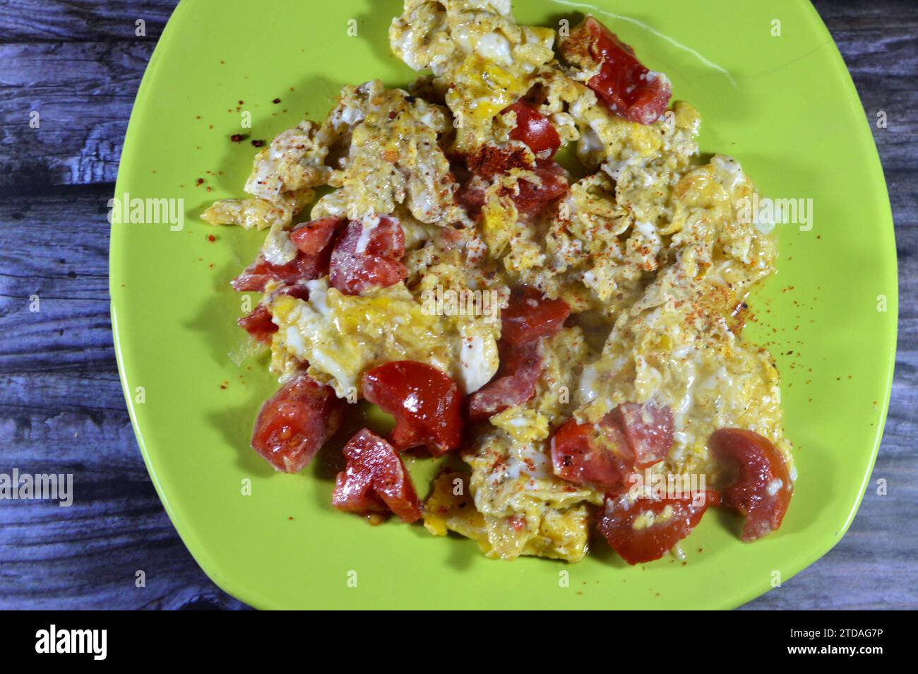 Uova strapazzate con pomodori, un piatto a base di uova mescolate, montate o sbattute insieme mentre vengono riscaldate delicatamente, con sale, burro, olio e pe nero Foto Stock