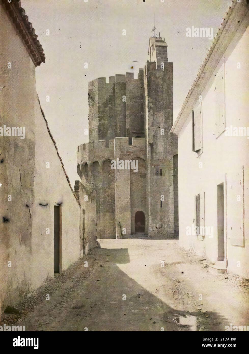 Saintes-Maries-de-la-Mer, Francia la chiesa fortificata di Notre-Dame-de-la-Mer, vista tratta da rue Chardon Rieu, religione, Habitat, architettura, arte, Chiesa, Cristianesimo, Campanile, architettura fortificata, via, distretto, Medioevo, architettura religiosa, Francia, Les Stes-Marie, Basilica-Chiesa fortificata di Saintes, Saintes-Maries-de-la-Mer, 16/04/1916 - 16/04/1916, Léon, Auguste, fotografo, 1916 - Province francesi - Jean Brunhes, Auguste Léon et Georges Chevalier - (aprile-luglio), Autochrome, Photo, Glass, Autochrome, foto, positivo, verticale, dimensioni 9 x 12 cm Foto Stock