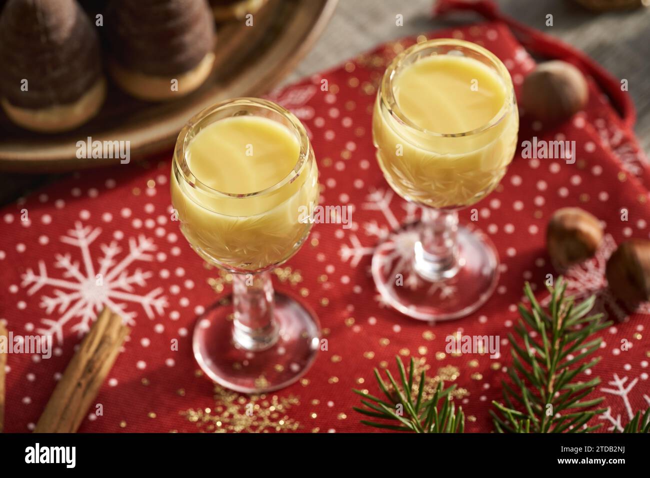 Eggnog cremoso in bicchieri da bicchieri con biscotti natalizi e decorazioni Foto Stock
