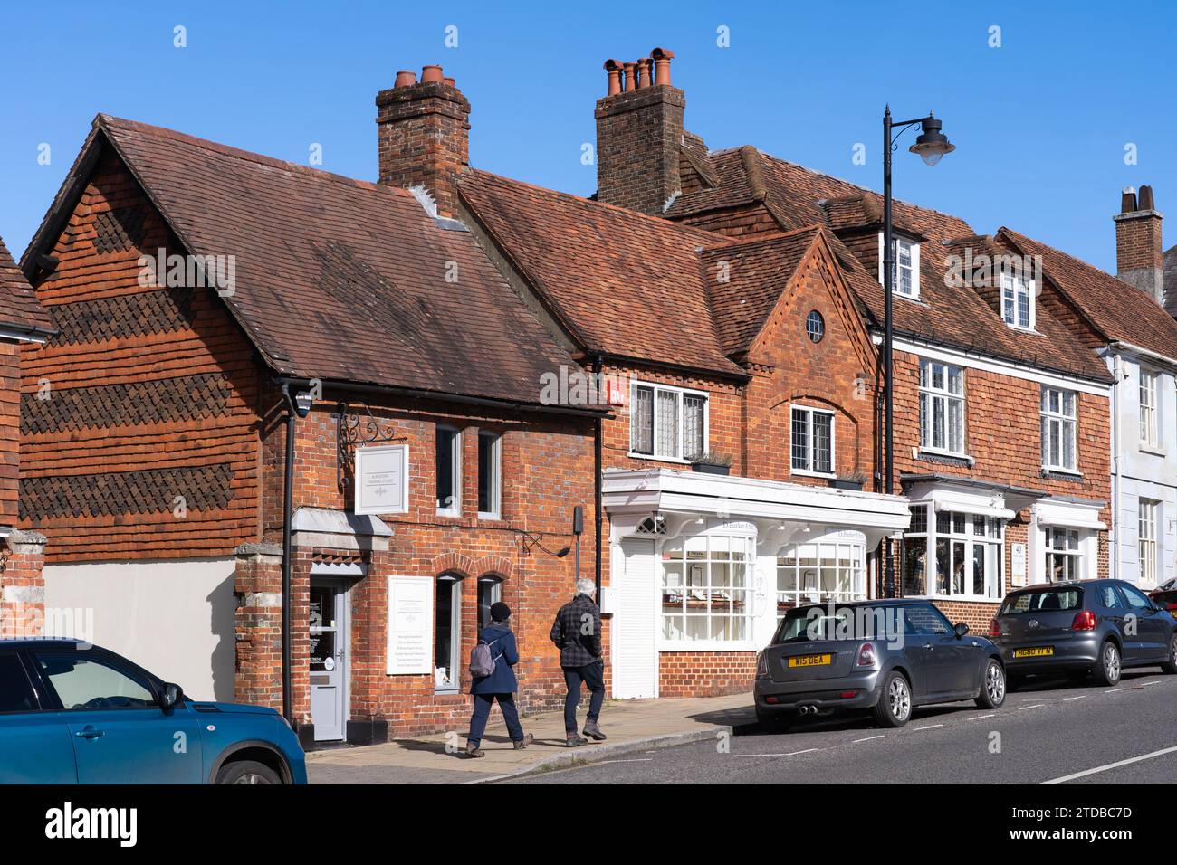 Gente che cammina lungo la collina di Avenue a New Alresford, una città commerciale con negozi indipendenti nel quartiere della città di Winchester nell'Hampshire, Regno Unito Foto Stock