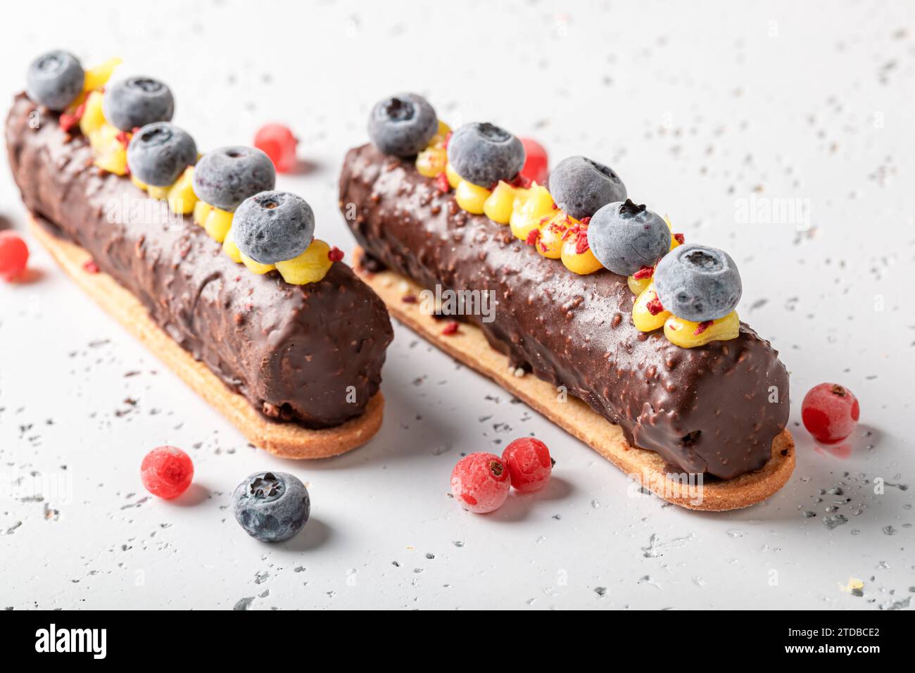 Gustosa barretta di cioccolato con panna acida e frutti di bosco su tavola in pietra Foto Stock