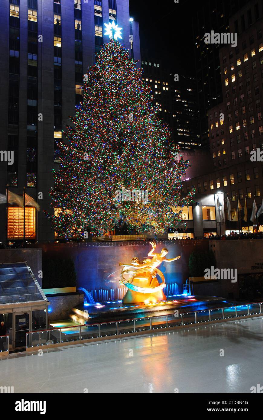 L'albero di Natale del Rockefeller Center brilla di fronte alla famosa pista di pattinaggio su ghiaccio di New York City Foto Stock