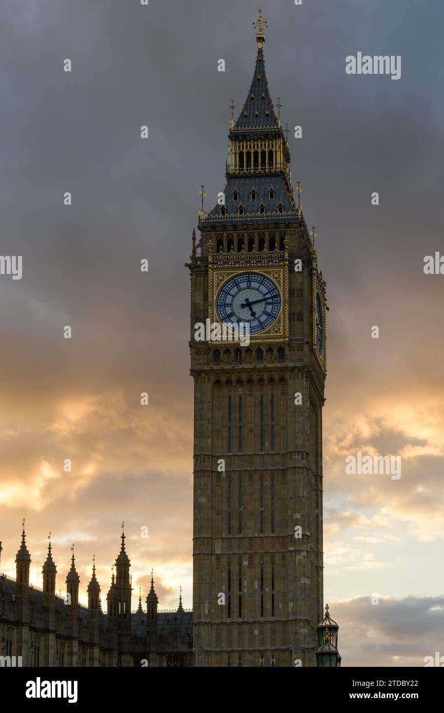 Elizabeth Tower retroilluminata con il Big Ben contro il cielo lungoso del tramonto Foto Stock