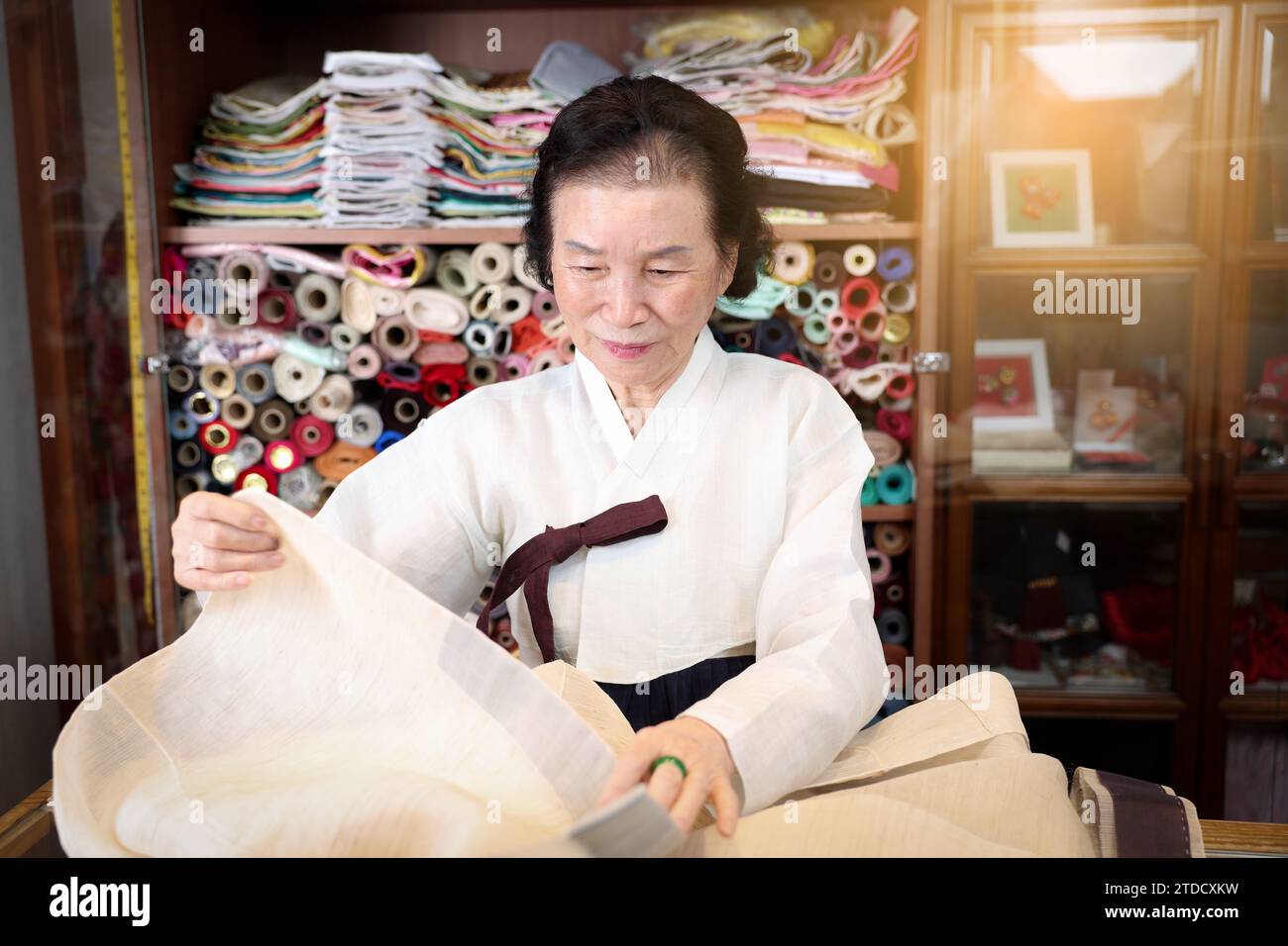 Un maestro di abbigliamento tradizionale coreano, un esperto di Hanbok, sta cucendo per la produzione Hanbok. Foto Stock