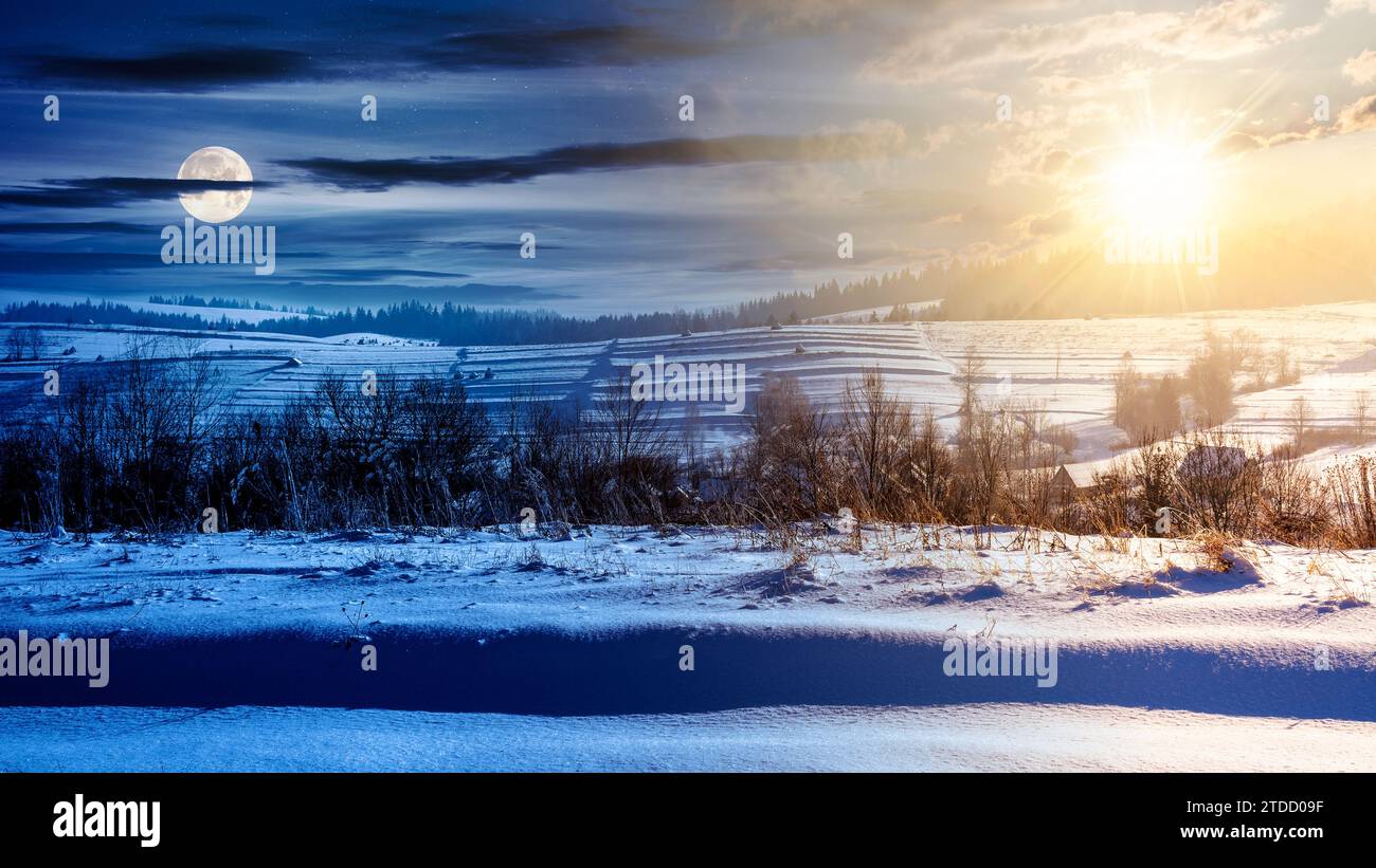paesaggio di campagna in una giornata di solstizio d'inverno. paesaggio rurale con colline innevate in lontananza sotto un cielo con sole e luna. giorno e. Foto Stock